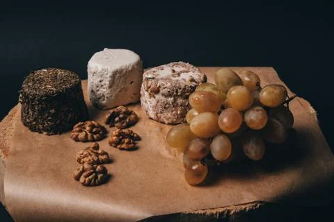 Cheese grapes and walnuts on rustic background Stock Photos