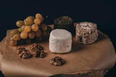 Cheese grapes and walnuts on rustic background Stock Photos