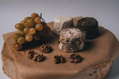 Cheese grapes and walnuts on rustic background Stock Photos