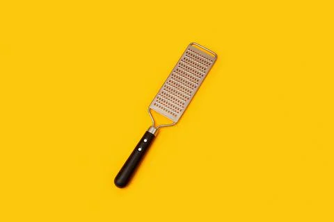Cheese graters on yellow background Stock Photos