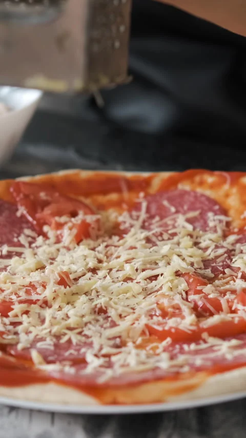 Cheese grating over tomato-sauced crust Vídeos de archivo 283492324
