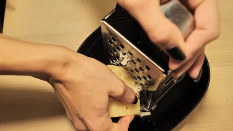 Cheese Grating Process on Wooden Table - A Blend of Precision and Craft, Close Stock Footage 296801662
