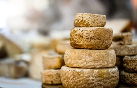 Cheese heads stacked on table Stock Photos