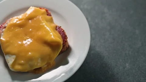 Cheese is melted on a slice of bread topped with an egg. A sandwich on a white Stock-Footage 338290321