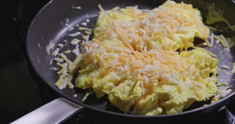 Cheese melting on scrambled eggs close up Stock Footage 311082188