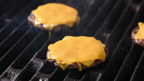 The cheese melts on the surface of the burger while it is grilled and cooked. Vídeo Stock 296071075