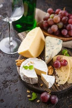Cheese with nuts and grapes Stock Photos