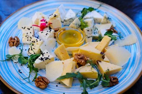 Cheese nuts garnish assorted cheese platter with brie, blue cheese, and hard Stock Photos