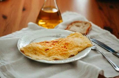 Cheese omelet with rustic bread and olive oil served on white tablecloth Stock Photos