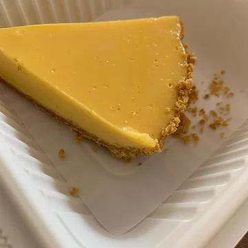 Cheese pie on a pink table, ready to enjoy dessert with ground biscuit base Stock Photos