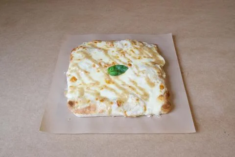 A cheese pizza with a basil leaf on top Stock Photos