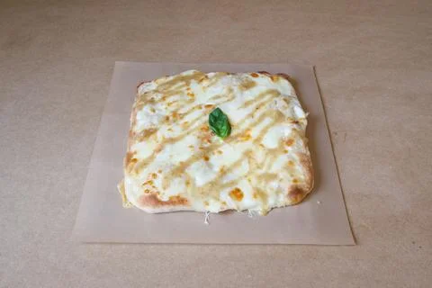 A cheese pizza with a basil leaf on top Stock Photos
