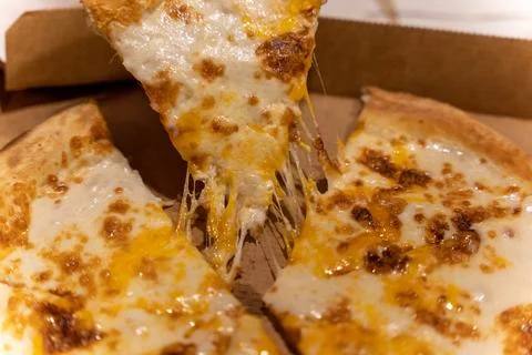Cheese pizza with melted cheese pulled from the box at a gathering Foto stock