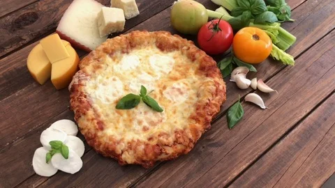 Cheese pizza surrounded by its ingredients Stock Footage 104987952