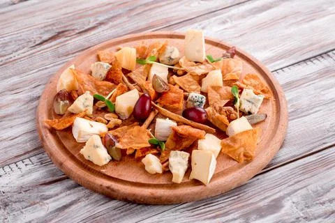 Cheese plate Assortment of various types of cheese on wooden cutting board on Stock Photos