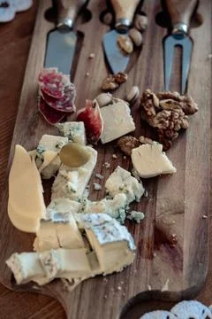 Cheese plate with different types, with walnuts and tasting devices, top view Stock Photos