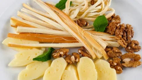 Cheese plate, including smoked chechil, suluguni and walnuts Stock Footage 84265136