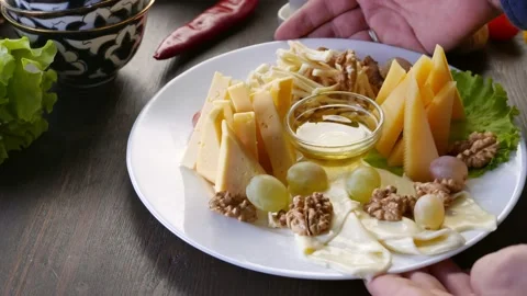 Cheese plate, served with different types of cheese, honey, walnuts and grapes Stock Footage 164983254