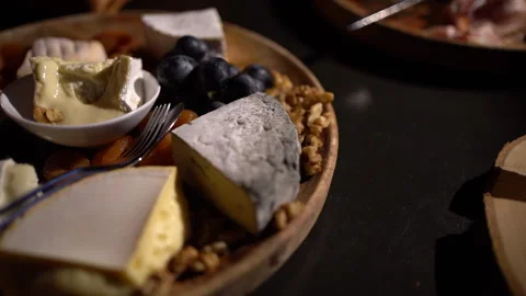Cheese plate - various types of cheese, grapes, dried apricots, nuts on a w.. Stock Footage 294978678