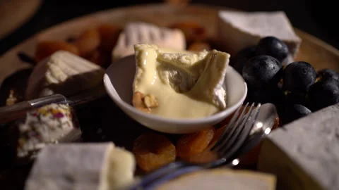 ..Cheese plate - various types of cheese, grapes, dried apricots, nuts on a w Stock Footage 294978713