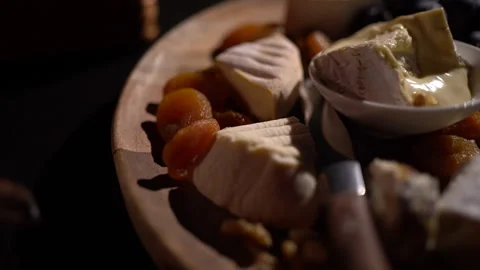 Cheese plate - various types of cheese, grapes, dried apricots, nuts on a w.. Stock Footage 294978950