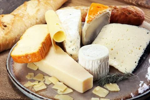 Cheese platter with different cheese on rustic plate. Stock Photos