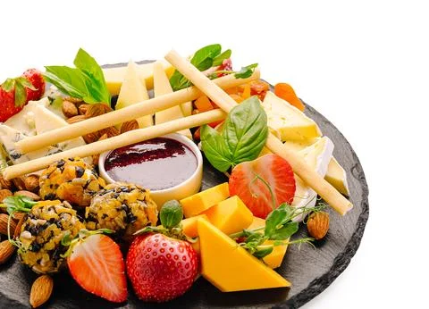 Cheese platter with fruit nuts jam and crackers Stock Photos
