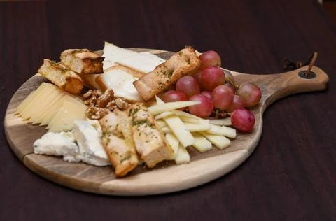 Cheese Platter with Grapes, Walnuts, and Toasted Bread Stock Photos