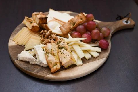 Cheese Platter with Grapes, Walnuts, and Toasted Bread Stock Photos