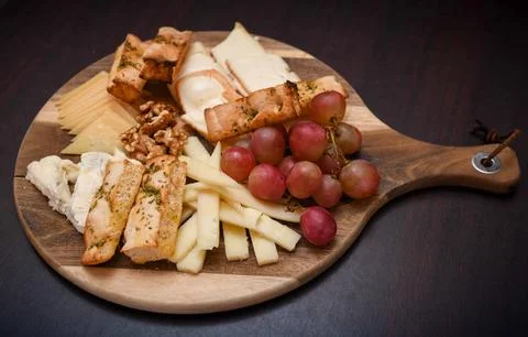 Cheese Platter with Grapes, Walnuts, and Toasted Bread Stock Photos