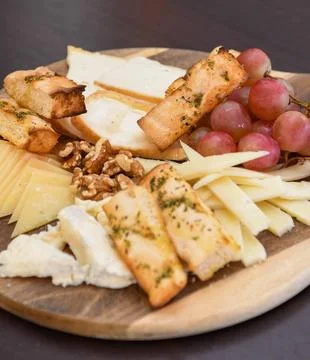 Cheese Platter with Grapes, Walnuts, and Toasted Bread Stock Photos