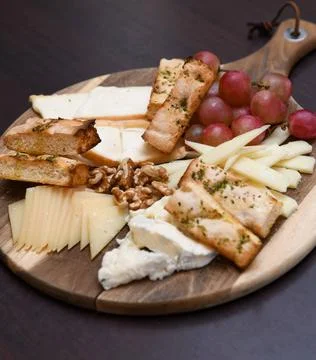 Cheese Platter with Grapes, Walnuts, and Toasted Bread Stock Photos