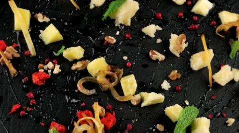 Cheese platter (walnut, fried onions, cranberry) on the black stone tray Stock Footage 66482628