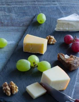 Cheese platter witch assorted cheese and grapes Stock Photos