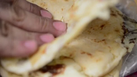 Cheese pupusas split by hand, revealing delectable cheese threads, in a cap.. Stock-Footage 274257453