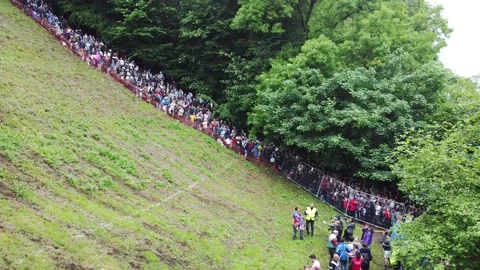Cheese Rolling Crowd 2022 at Cooper's Hill, Brockworth, UK. Tracking drone Stock Footage 197368154