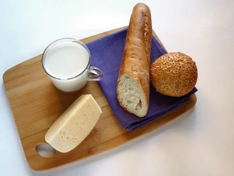The cheese is a round head cut with bread, baguette, sesame bun. Stock Photos