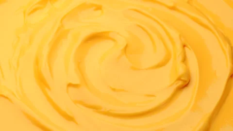 Cheese sauce rotating in circle with smooth creamy texture and rich color Stock Footage 310338832