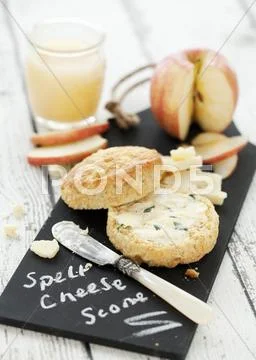 A cheese scone with herb butter, cheese and apple Stock Photos