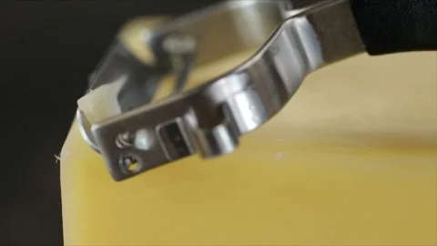 Cheese Scraper is pulled over Cheese Slowmotion Closeup Stock Footage 99198016