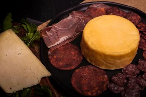 Cheese with serrano ham, olives on a table for a party with friends or as an  Stock Photos