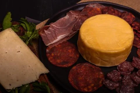 Cheese with serrano ham, olives on a table for a party with friends or as an  Stock Photos