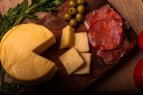 Cheese with serrano ham, olives on a table for a party with friends or as an  Foto stock