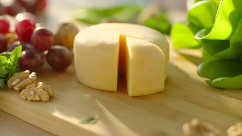 Cheese served with green, grape and walnut. Hand taking cut piece of cheese Stock Footage 169751378