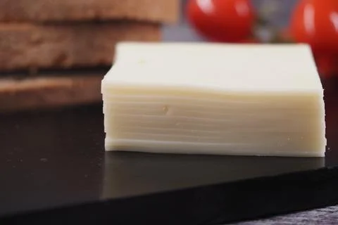 Cheese slice on a black cutting board with bread Stock Photos