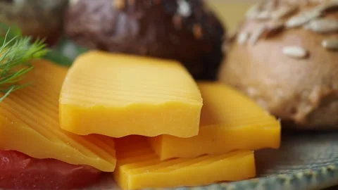 Cheese slices with bread rolls on a plate Stock Footage 334697460