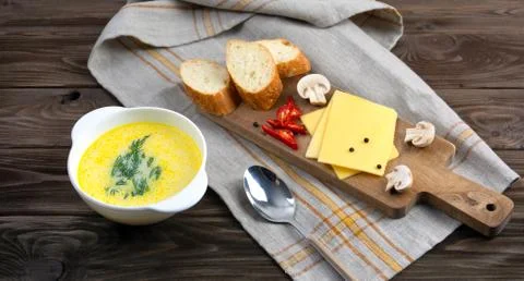 Cheese soup with bread, mushrooms, cheese and pepper on a wooden background. Stock Photos