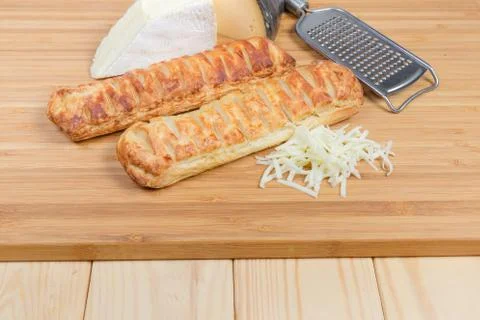 Cheese-stuffed bread sticks, different cheese on wooden cutting board Stock Photos