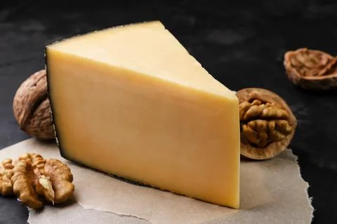 Cheese with walnuts close-up on a dark background. Stock Photos