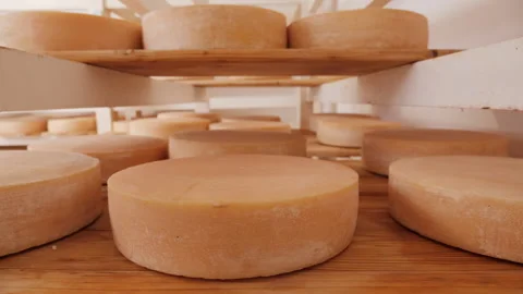 Cheese wheels maturing on shelves - camera slide Video stock 154083409